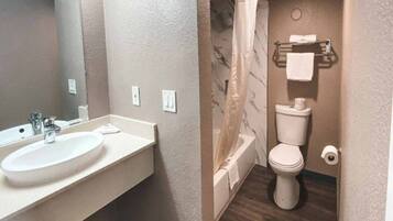 A bathroom with a sink, toilet, and shower curtain.