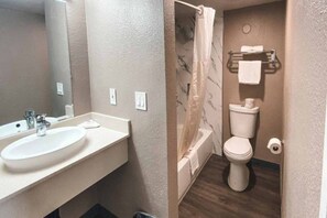 Een badkamer met een wastafel, toilet en douchegordijn.