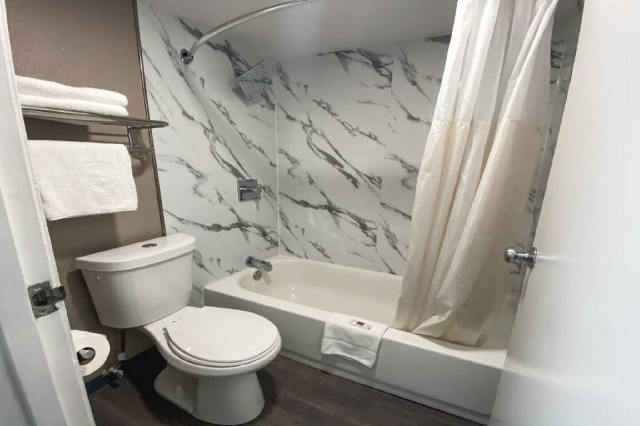 Ein Badezimmer mit Toilette, Badewanne und Duschvorhang.