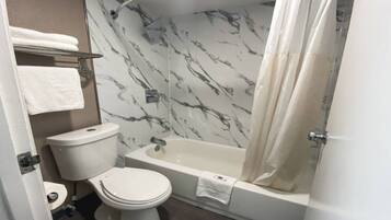 Ein Badezimmer mit Toilette, Badewanne und Duschvorhang.