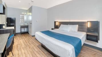 Ein modernes Hotelzimmer mit Bett, Nachttischen, Schreibtisch und Stuhl.