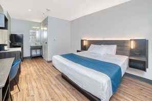 Une chambre d’hôtel moderne équipée d’un lit, de tables de chevet, d’un bureau et d’une chaise.