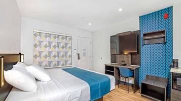 A hotel room with a bed, a desk, a TV, and a microwave.