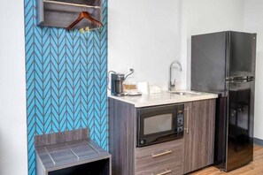 Une petite cuisine équipée d’un four à micro-ondes, d’une machine à café et d’un réfrigérateur.