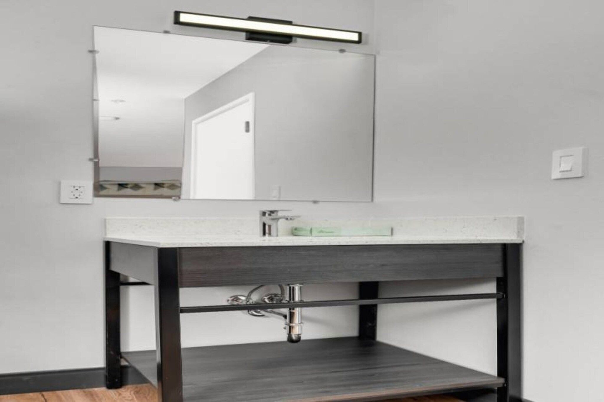 A bathroom vanity with a mirror, sink, and cabinet.
