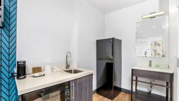 A compact kitchen with a microwave, coffee maker, and a refrigerator.