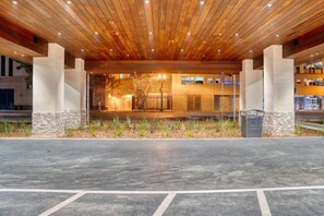 Un edificio con techo de madera y un área de entrada empavedada.