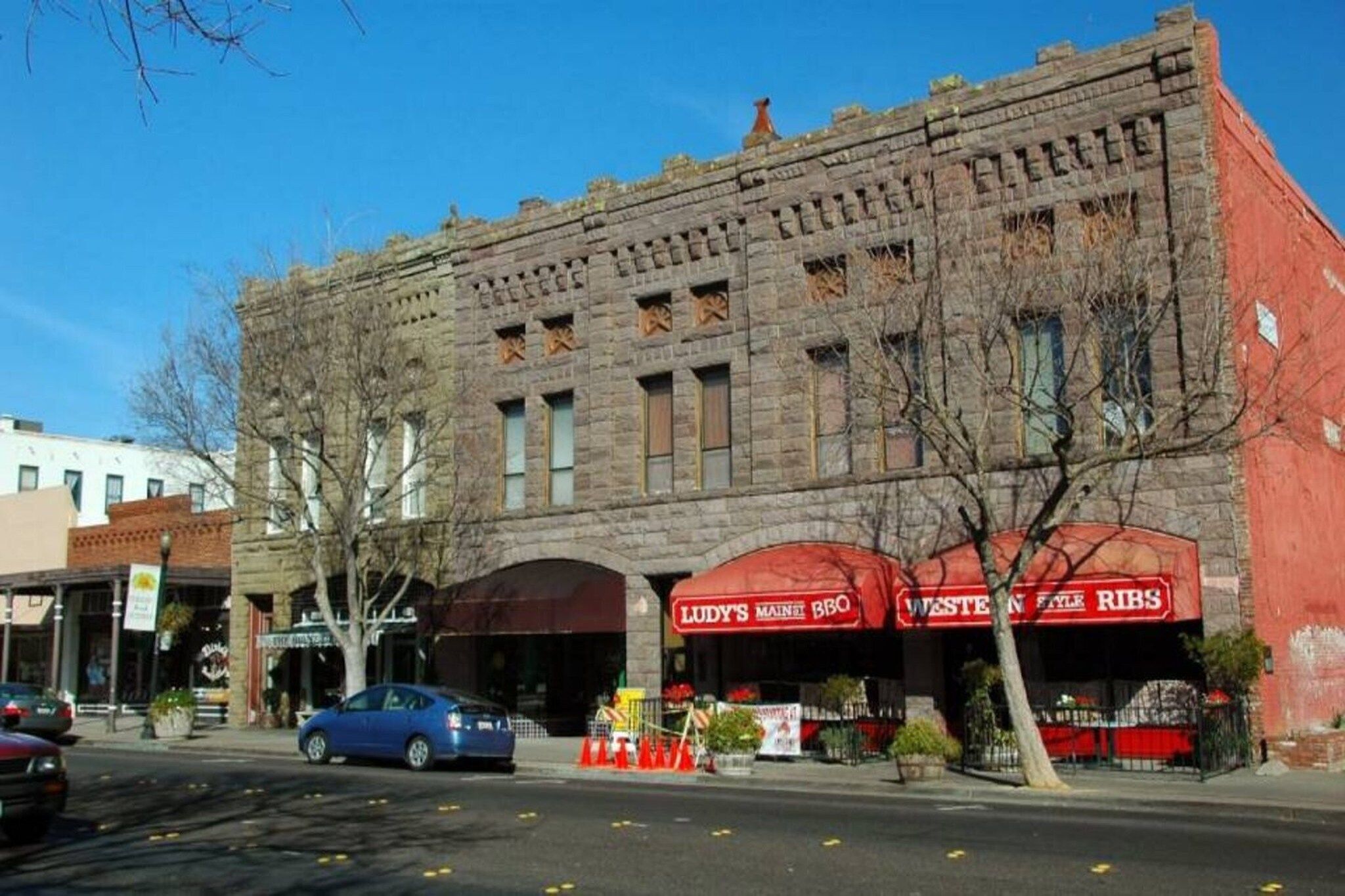 A historic building with two storefronts, one for a BBQ and another for Western Style Ribs.