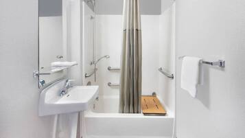 A modern bathroom with a bathtub, a sink, and a mirror.