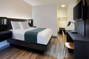 Una habitación de hotel moderna con una cama, mesitas de noche, un escritorio, una silla y un televisor.