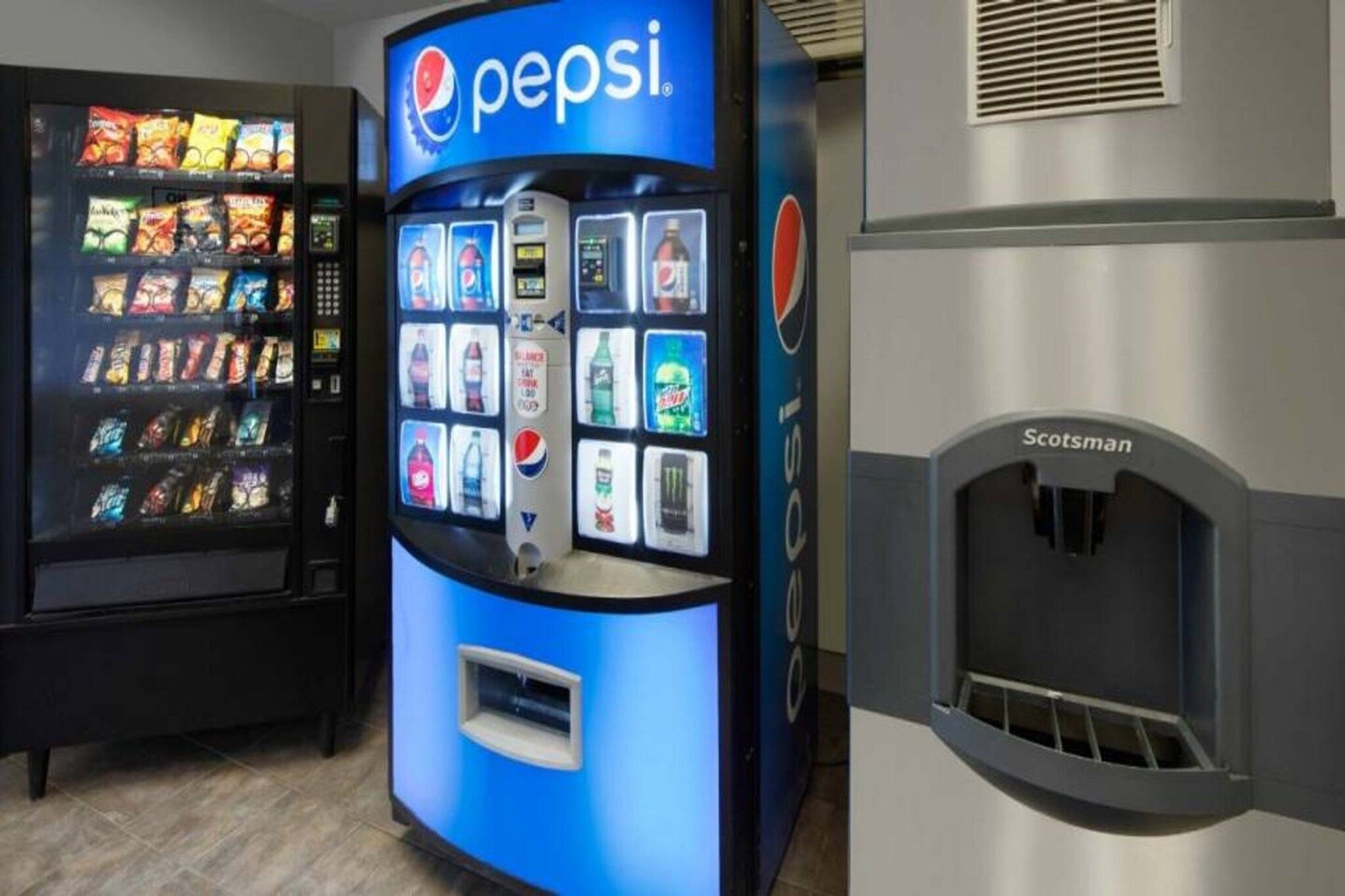 A vending machine with a Pepsi logo, a selection of snacks, and a drink dispenser.