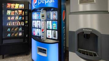 A vending machine with a Pepsi logo, a selection of snacks, and a drink dispenser.