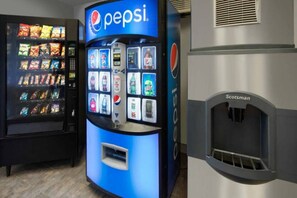 Máquina de vendas com logotipo da Pepsi, variedade de lanches e dispensador de bebidas.