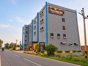 A multi-story building with a sign reading 'Chocolate Inn Hotels & Resorts.'