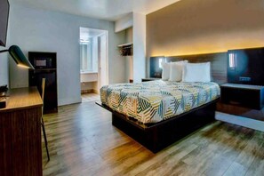 Een hotelkamer met een bed, nachtkastjes, een bureau en een kledingkast.