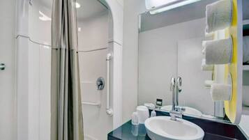 A modern bathroom with a shower, a sink, and a mirror.