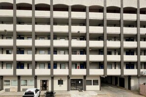 A multi-story building with a uniform facade, balconies on each floor, and a ground-level entrance.