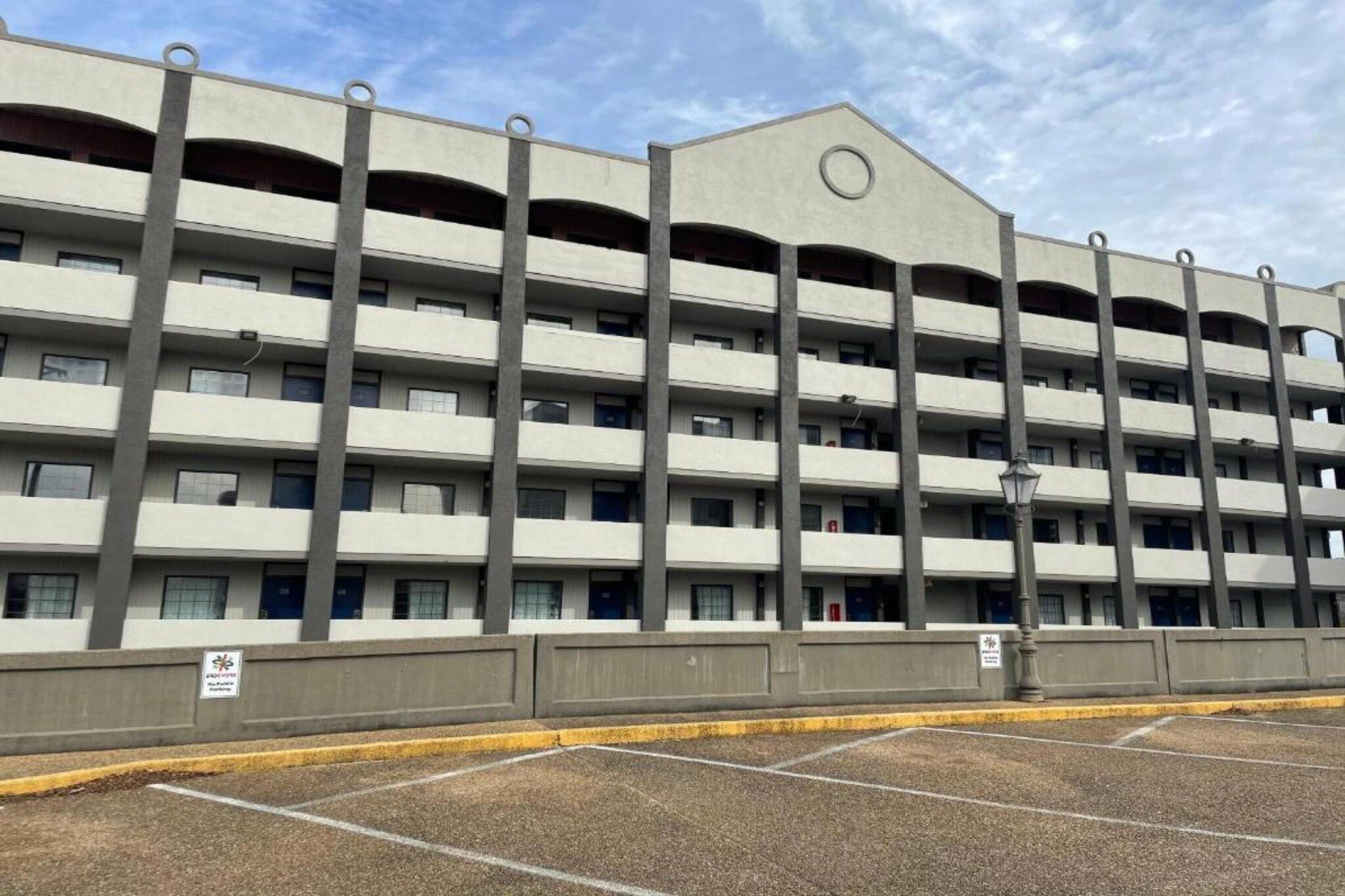 Un parking à étages doté d’un toit plat et de plusieurs balcons à chaque niveau.