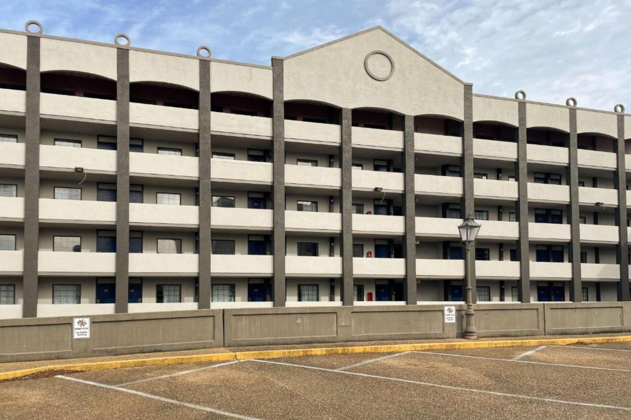 A multi-story parking garage with a flat roof and a central circular feature.
