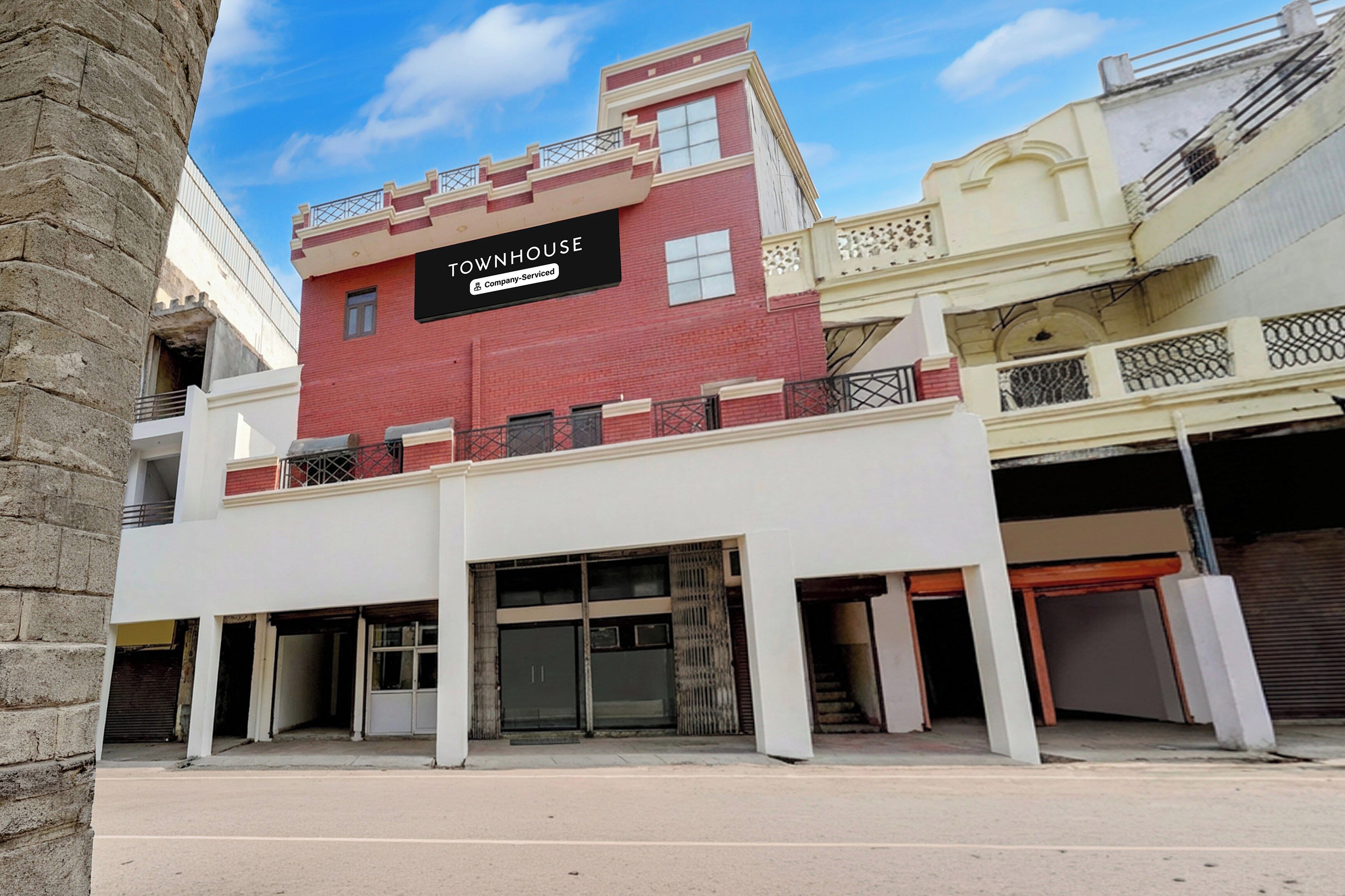 A multi-story building with a sign indicating it is a company-serviced townhouse.
