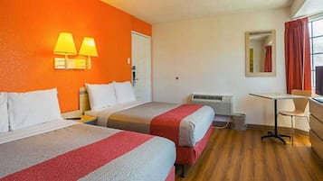Une chambre d’hôtel avec deux lits, un bureau, une chaise, un miroir et une fenêtre avec des rideaux.