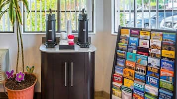 Une pièce avec un meuble en bois foncé, une plante en pot et un présentoir rempli de brochures de voyage.