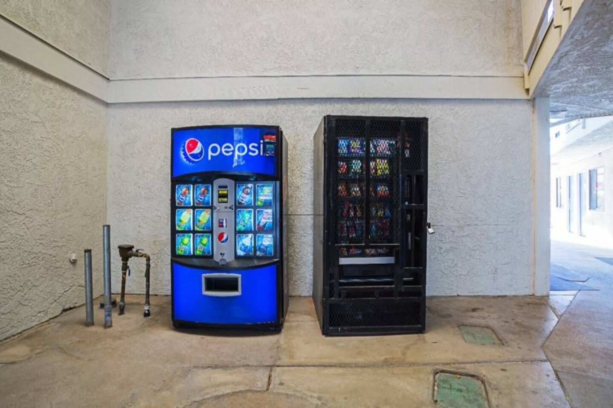 Un distributeur automatique de Pepsi et une vitrine contenant des articles aux couleurs vives.