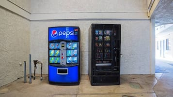 Un distributeur automatique de Pepsi et une vitrine contenant des articles aux couleurs vives.