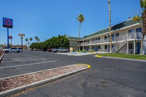Un motel avec un parking, un panneau indiquant la présence d’un restaurant Denny’s et un panneau indiquant le numéro 6.