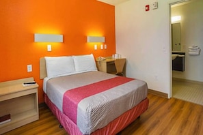 A hotel room with a bed, bedside table, and a desk with a telephone. - 1 Queen Bed | Micfridge | Smoking (Yuma AZ)