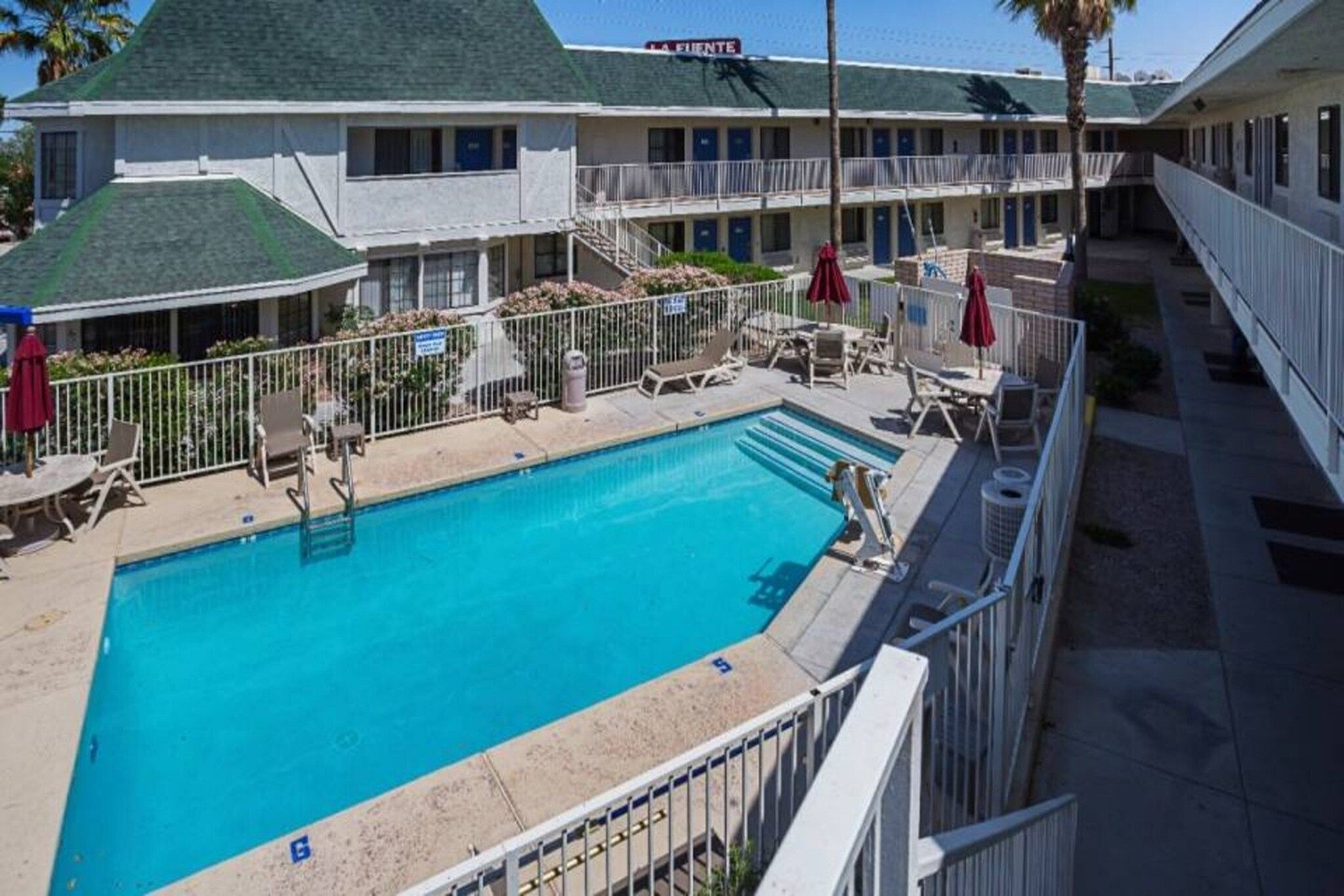 Un hôtel doté d’une piscine, d’un espace extérieur aménagé et d’un bâtiment à deux étages.
