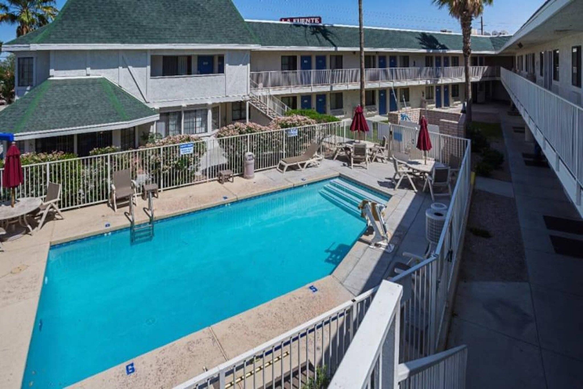 Un hôtel doté d’une piscine, d’un espace extérieur aménagé et d’une galerie couverte.