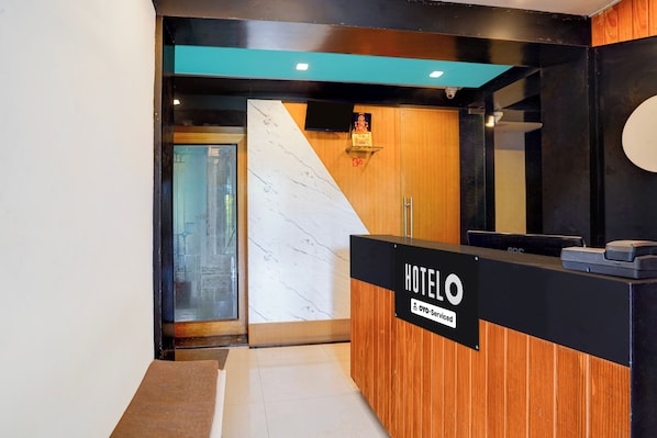 A hotel reception desk with a sign indicating it is OVO-Serviced. - Hotel O Khadakwasla Lake (Pune)