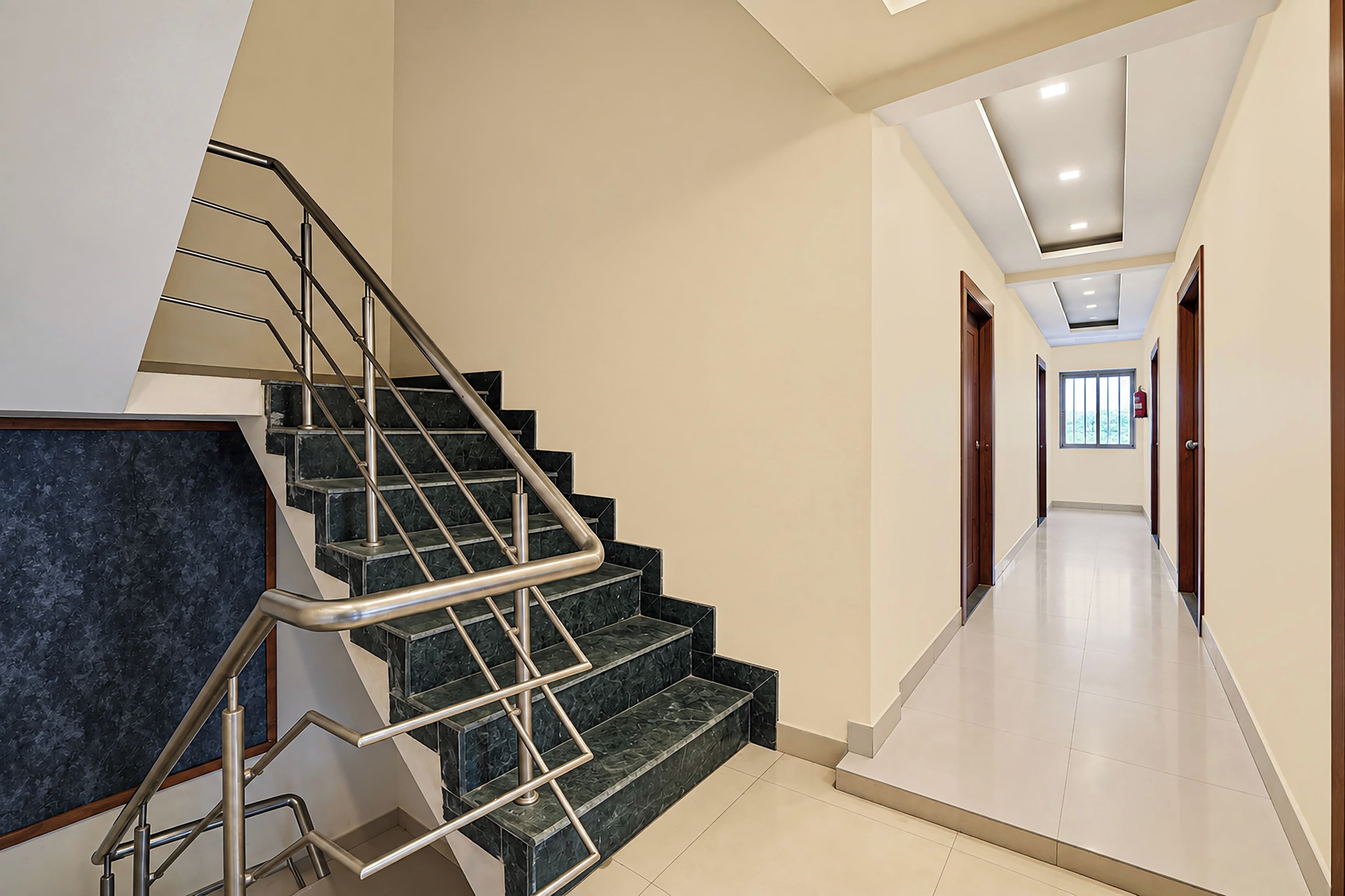 A modern interior with a staircase, a hallway, and a door leading to another room.