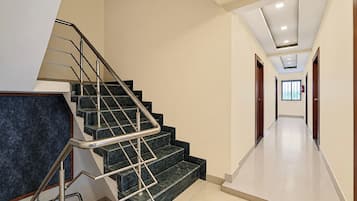 A modern interior with a staircase, a hallway, and a door leading to another room.