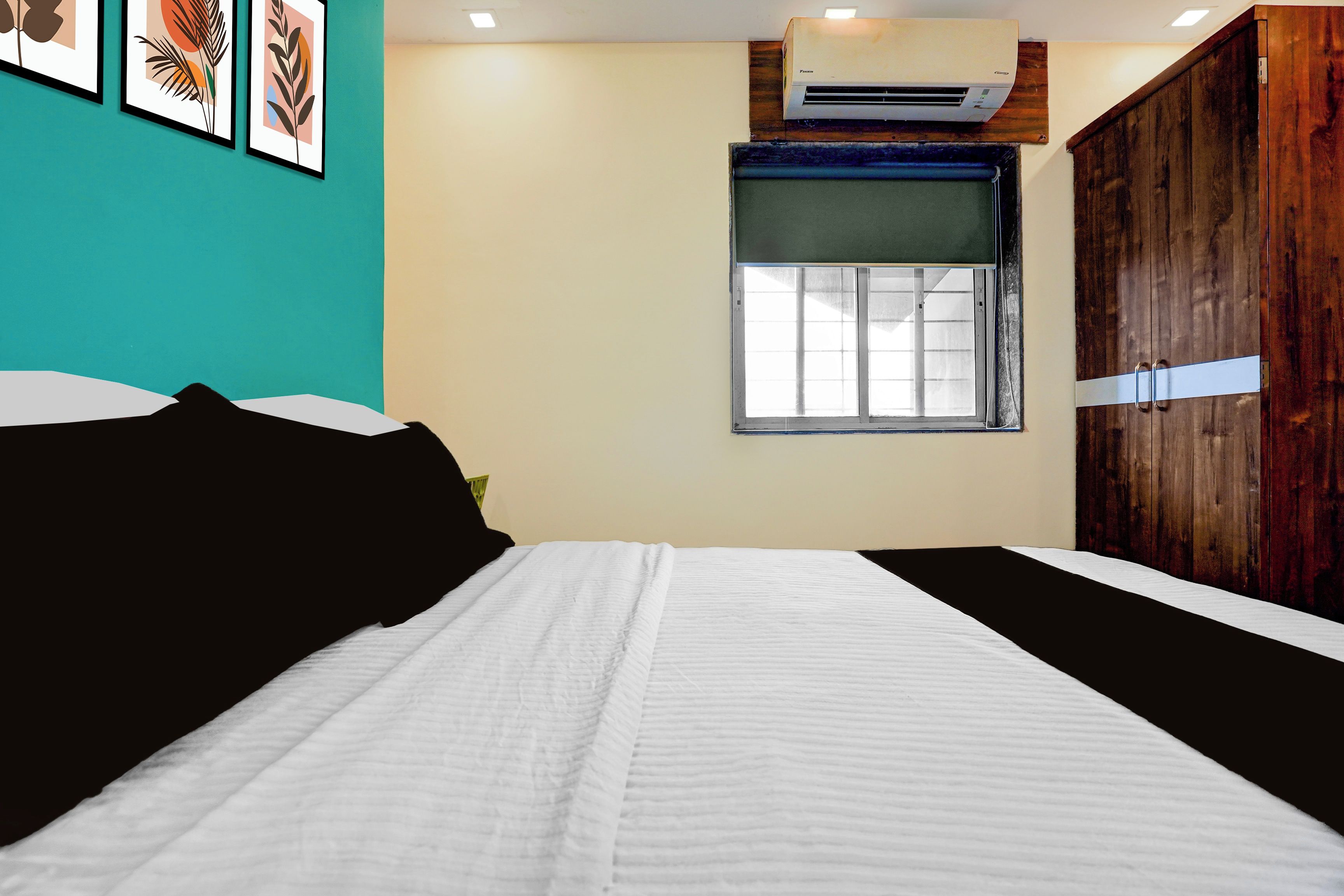 Un dormitorio con una cama, ventana, aire acondicionado y armario.