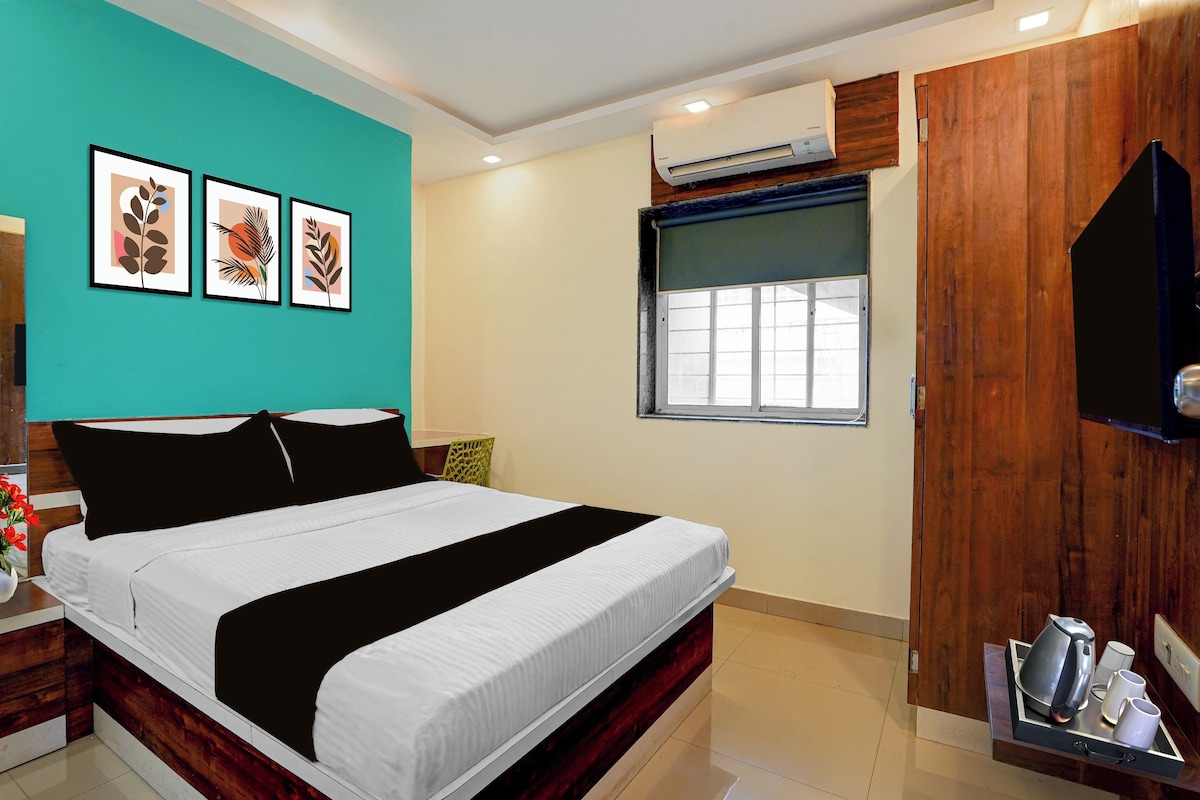 A bedroom with a bed, a window, an air conditioning unit, and wall art.