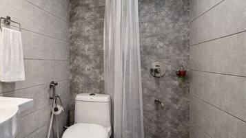A small, modern bathroom with a toilet, shower, and sink.