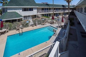 Ein Hotel mit Schwimmbad, Außenbereich und einem überdachten Gang.