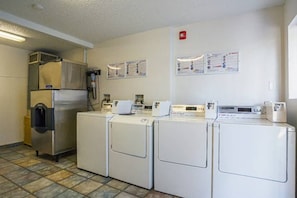 A laundry room with four washing machines, a large refrigerator, and a water heater. - 1 Queen Bed | Hearing Accessible Micfridge (Yuma AZ)
