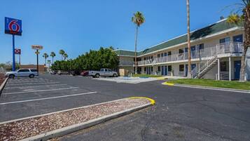 A motel with a parking lot, a sign for Denny's, and a 6 Motel sign.