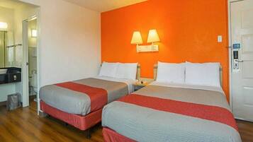 A hotel room with two beds, a bathroom, and a hallway.