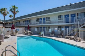 A hotel with a swimming pool, outdoor seating, and a two-story building. - 2 Queen Beds | Premium, Micfridge (Yuma AZ)
