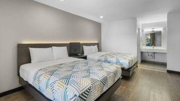 Une chambre d’hôtel avec deux lits, un grand miroir et un plancher en bois.