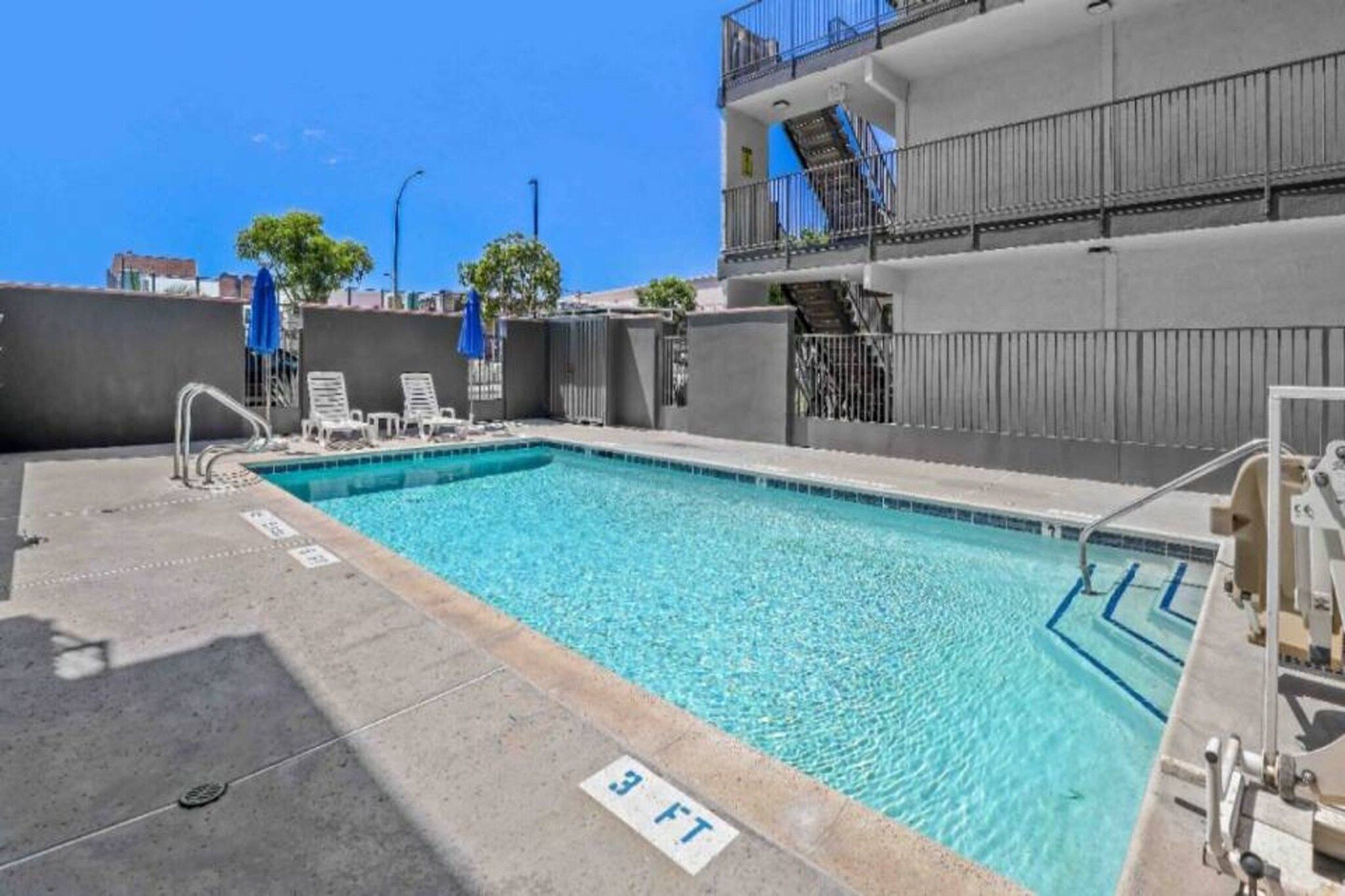A rooftop pool with clear blue water, a diving board, and a 3 FT depth marker.