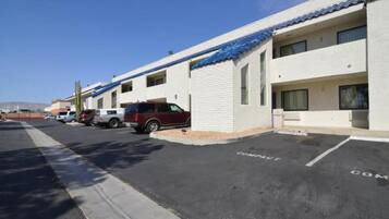 A row of single-story motel buildings with compact parking spaces.