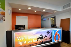 A hotel reception desk with a sign that reads 'We'll leave the light on for you.'