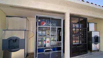 Un espace comprenant un distributeur automatique orné du logo Pepsi, un autre distributeur de la marque Scotman et un appareil réfrigérant.