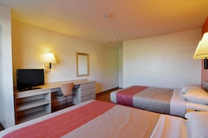 Quarto de hotel com duas camas, uma escrivaninha, uma cadeira e uma televisão.