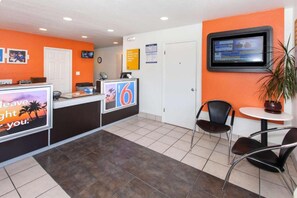 A reception area with a counter, a television, and seating. - 2 Full Beds | Micfridge (Rosemead)